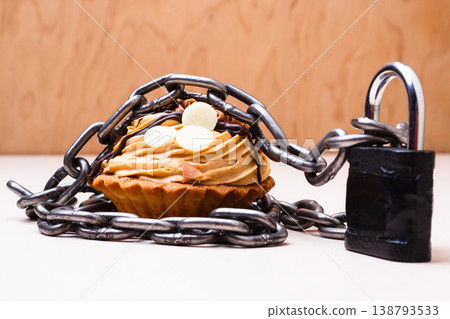 Cake with chain and padlock, diet concept. Cake with chain and padlock, diet concept. 138793533