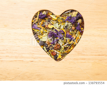 Dried herb leaves heart shaped on wooden surface Dried herb leaves heart shaped on wooden surface 138793554