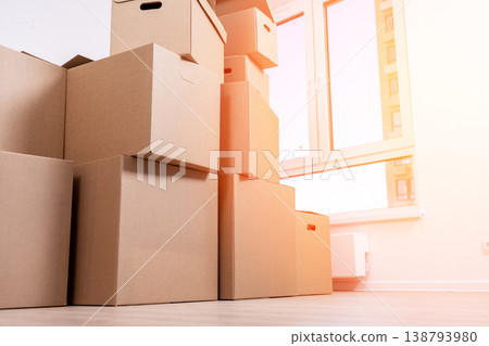 Cardboard boxes are piled high in a bright room Cardboard boxes are piled high in a bright room 138793980