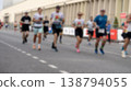 Blurred runners sprint down a city street 138794055