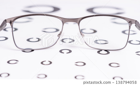 Silver-framed eyeglasses sit atop a visual acuity chart 138794058