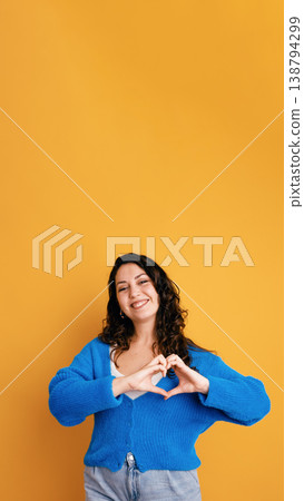 Young woman showing heart gesture, spreading love and happiness 138794299