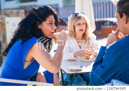 Friends enjoying coffee and conversation at outdoor cafe Friends enjoying coffee and conversation at outdoor cafe 138794395