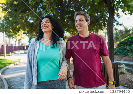 Happy couple walking and smiling in park Happy couple walking and smiling in park 138794400