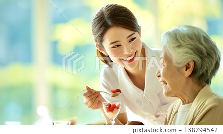 A moment of gentle mealtime assistance, connected by smiles. 138794542