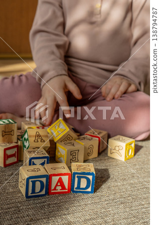 Baby stacking wooden blocks in a word dad. Concept of Fathers day. Baby stacking wooden blocks in a word dad. Concept of Fathers day. 138794787