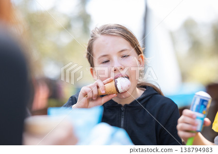 Young girl enjoying an ice cream cone outdoors 138794983