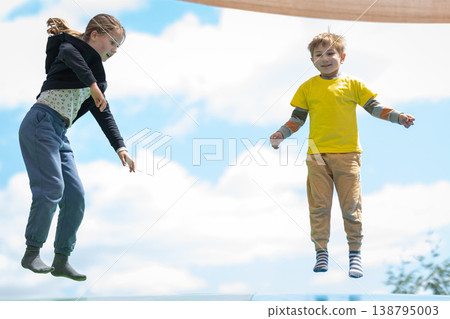 Happy children jumping high enjoying outdoor activity Happy children jumping high enjoying outdoor activity 138795003