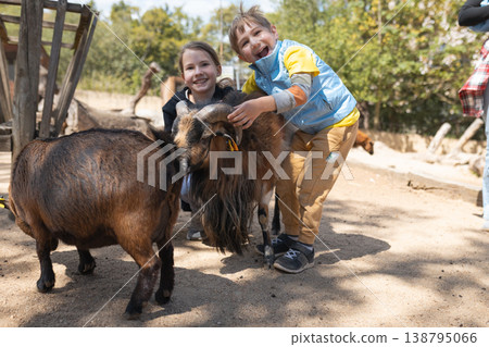 Happy children petting goats at animal farm Happy children petting goats at animal farm 138795066