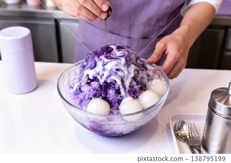 Traditional Japanese kakigori with purple syrup poured over shaved ice bowl 138795199