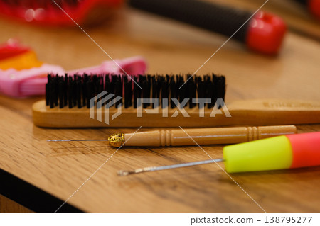 Hair styling tools on wooden table with brush and crochet hooks Hair styling tools on wooden table with brush and crochet hooks 138795277