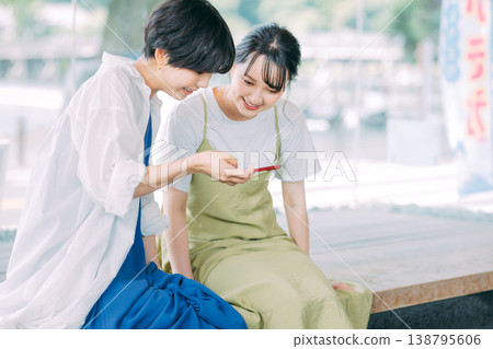 一位女士一邊享受泡腳，一邊看著她的智慧型手機。 138795606