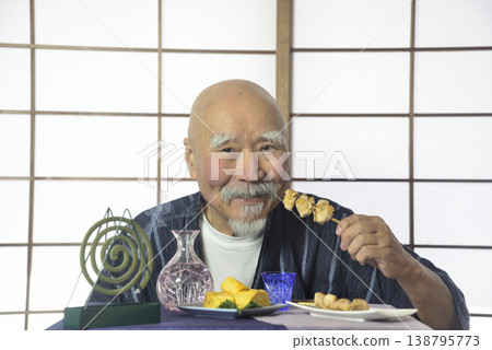 A bearded old man drinking sake in a Japanese-style room. 138795773