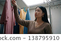 A woman hanging up laundry that she had dried indoors. 138795910