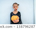 Halloween Celebration With a Young Girl Holding a 138796287