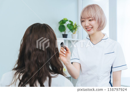 Female staff with light-colored hair doing makeup Female staff with light-colored hair doing makeup 138797924