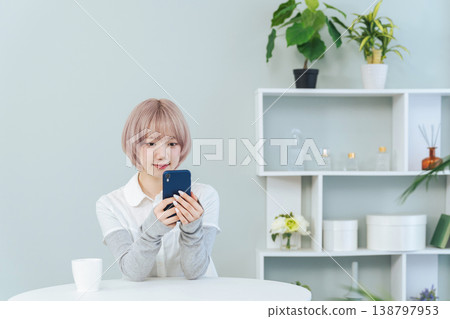 A woman with light-colored hair using a smartphone A woman with light-colored hair using a smartphone 138797953