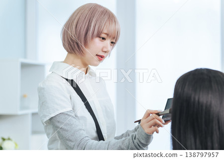 Female staff with light-colored hair doing makeup 138797957