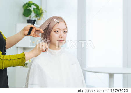 一位淺色頭髮的女士正在理髮。 138797970