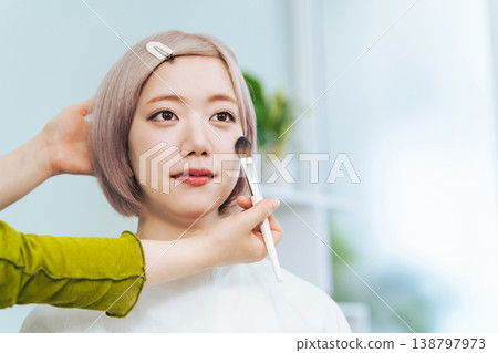 一位淺色頭髮的女士正在化妝。 138797973