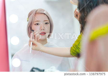 一位淺色頭髮的女士正在做頭髮和化妝。 138797975
