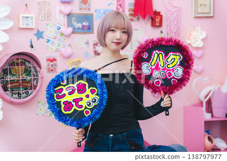 A woman with light-colored short bob hair holding a fan for her favorite idol. A woman with light-colored short bob hair holding a fan for her favorite idol. 138797977