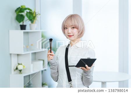 淺色頭髮的女員工手持化妝工具。 淺色頭髮的女員工手持化妝工具。 138798014