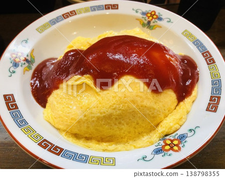 Omelet rice served in a Chinese-style bowl with ketchup. 138798355