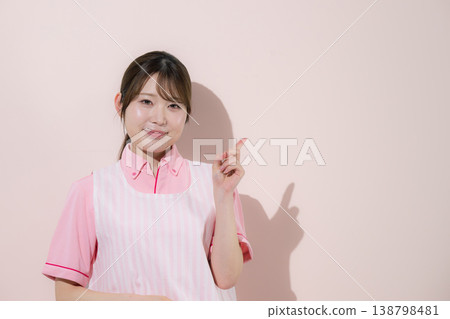一張粉紅色背景的圖片,圖片中一位女性正在從事護理員或育兒工作,突顯了她居家護理工作的回報性質以及指出關鍵點的重要性。 一張粉紅色背景的圖片,圖片中一位女性正在從事護理員或育兒工作,突顯了她居家護理工作的回報性質以及指出關鍵點的重要性。 138798481