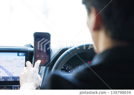 Businessmen operating their smartphones while driving. Businessmen operating their smartphones while driving. 138798639