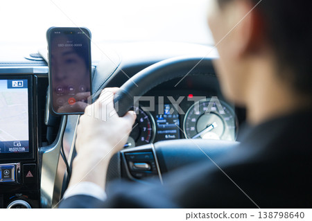 邊開車邊操作智慧型手機的商務人士。 138798640