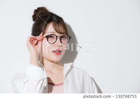A cute and beautiful beauty image featuring a bun hairstyle that suits glasses (sunglasses) against a white background, with the glasses slightly adjusted. A cute and beautiful beauty image featuring a bun hairstyle that suits glasses (sunglasses) against a white background, with the glasses slightly adjusted. 138798753