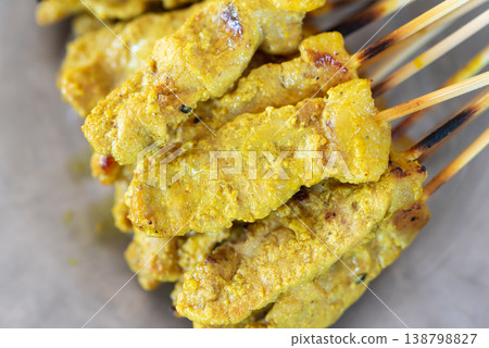Closeup of grilled pork satay skewers with golden turmeric marinade rich texture and juicy meat perfect for street food and asian cuisine concepts 138798827