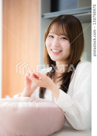 A woman doing self-nail care at home; a beauty lifestyle image of a woman polishing her nails with a nail file. 138798978