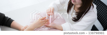 美甲沙龍的女美甲師提供周到的客戶服務、美容服務和諮詢。 138798981