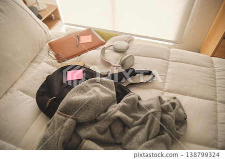 Student backpack and accessories on bed for campus living Student backpack and accessories on bed for campus living 138799324