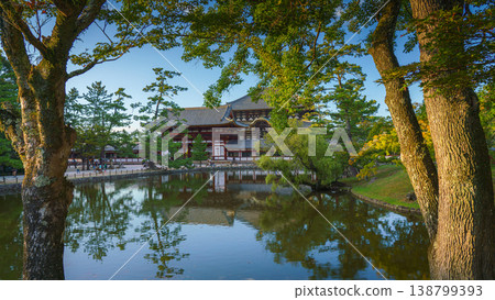 Nara, Japan - Sep 26 2024, Panoramic view across the pond and trees to the facade of Todaiji Temple, Great Buddha Hall, with a blue cloudy sky, Nara, Japan Nara, Japan - Sep 26 2024, Panoramic view across the pond and trees to the facade of Todaiji Temple, Great Buddha Hall, with a blue cloudy sky, Nara, Japan 138799393