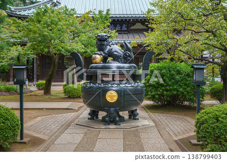 Tokyo, Japan - Sep 30 2024, Panoramic view of the bronze incense burner decorated with a lion statue, surrounded by trees, on road to Gotokuji Temple, without people, at daytime, Tokyo, Japan 138799403