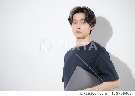 Young freelance engineers and designers working on their laptops, looking directly at the camera against a white background. Young freelance engineers and designers working on their laptops, looking directly at the camera against a white background. 138799462