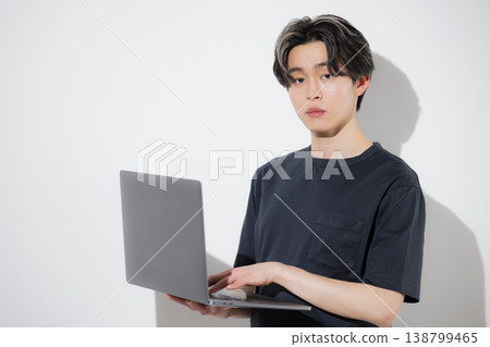 Young freelance engineers and designers working on their laptops, looking directly at the camera against a white background. Young freelance engineers and designers working on their laptops, looking directly at the camera against a white background. 138799465