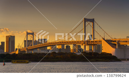 Tokyo, Japan - Oct 13 2024, panoramic view of Tokyo Bay with a cable-stayed Rainbow Bridge above it, a boat and a water bus sailing, at sunset, Tokyo, Japan Tokyo, Japan - Oct 13 2024, panoramic view of Tokyo Bay with a cable-stayed Rainbow Bridge above it, a boat and a water bus sailing, at sunset, Tokyo, Japan 138799624