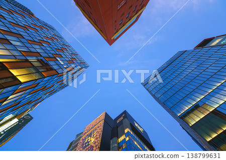Tokyo, Japan - Oct 14 2024, A panoramic view from below of a cross-shaped space between skyscrapers against a blue sky in the Ginza district, at evening, Tokyo, Japan Tokyo, Japan - Oct 14 2024, A panoramic view from below of a cross-shaped space between skyscrapers against a blue sky in the Ginza district, at evening, Tokyo, Japan 138799631