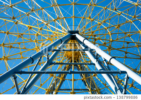 Detailed geometric view of yellow and blue steel bracing of a large observation wheel Detailed geometric view of yellow and blue steel bracing of a large observation wheel 138799886