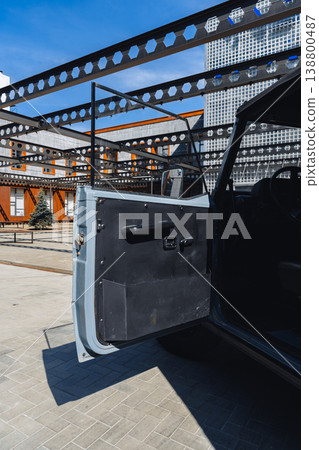 Classic car door open in urban area during daytime with modern architecture in background Classic car door open in urban area during daytime with modern architecture in background 138800487