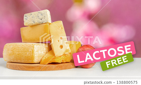 Lactose free cheese blocks stacked on a wooden board with a pink background Lactose free cheese blocks stacked on a wooden board with a pink background 138800575