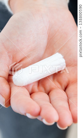 Woman holds a sanitary product in her hand during a personal care moment 138800590