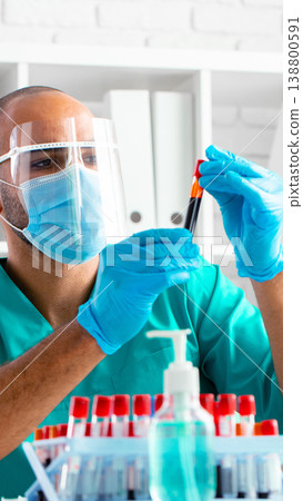 Laboratory technician works with blood samples in a clean environment during daylight hours Laboratory technician works with blood samples in a clean environment during daylight hours 138800591