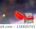 Bottle with orange cap sitting on table indoors during daytime 138800743