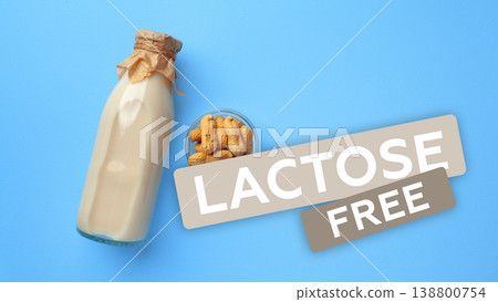 Lactose free milk and peanuts on a plain blue surface in a simple kitchen setting 138800754