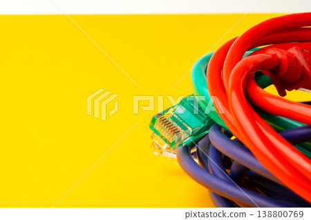 Colorful cables arranged on a yellow background with one connector visible on the side 138800769